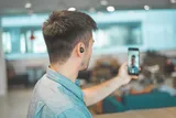 A man on a video call with earphones in busy answering an LVA assessment.