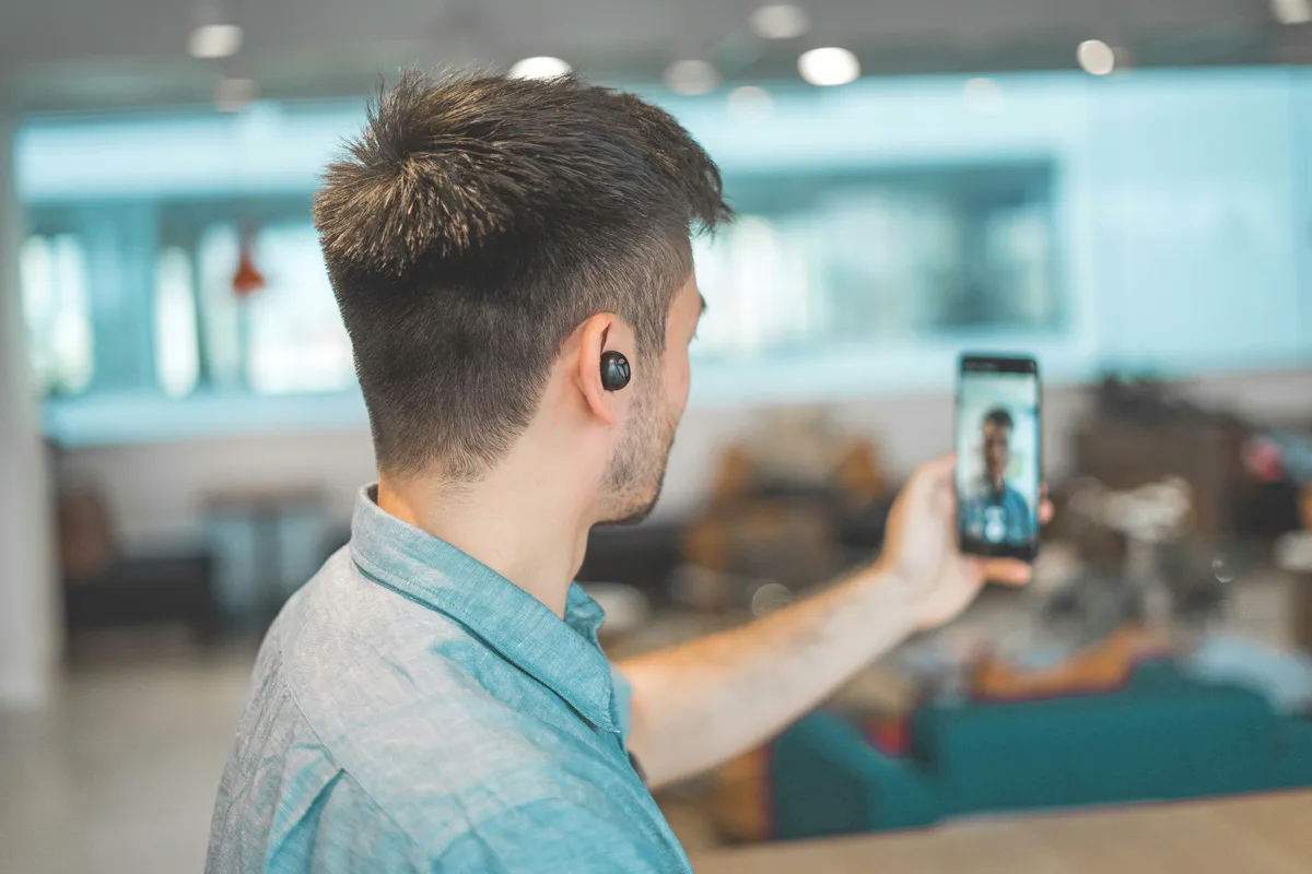 A man on a video call with earphones in busy answering an LVA assessment.